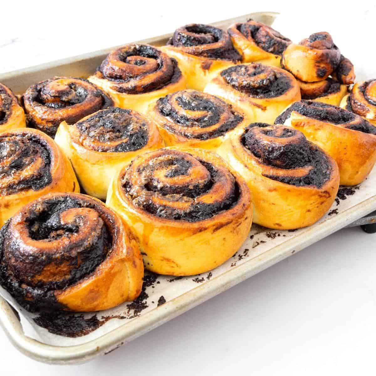 A baking tray with baked cinnamon chocolate rolls.