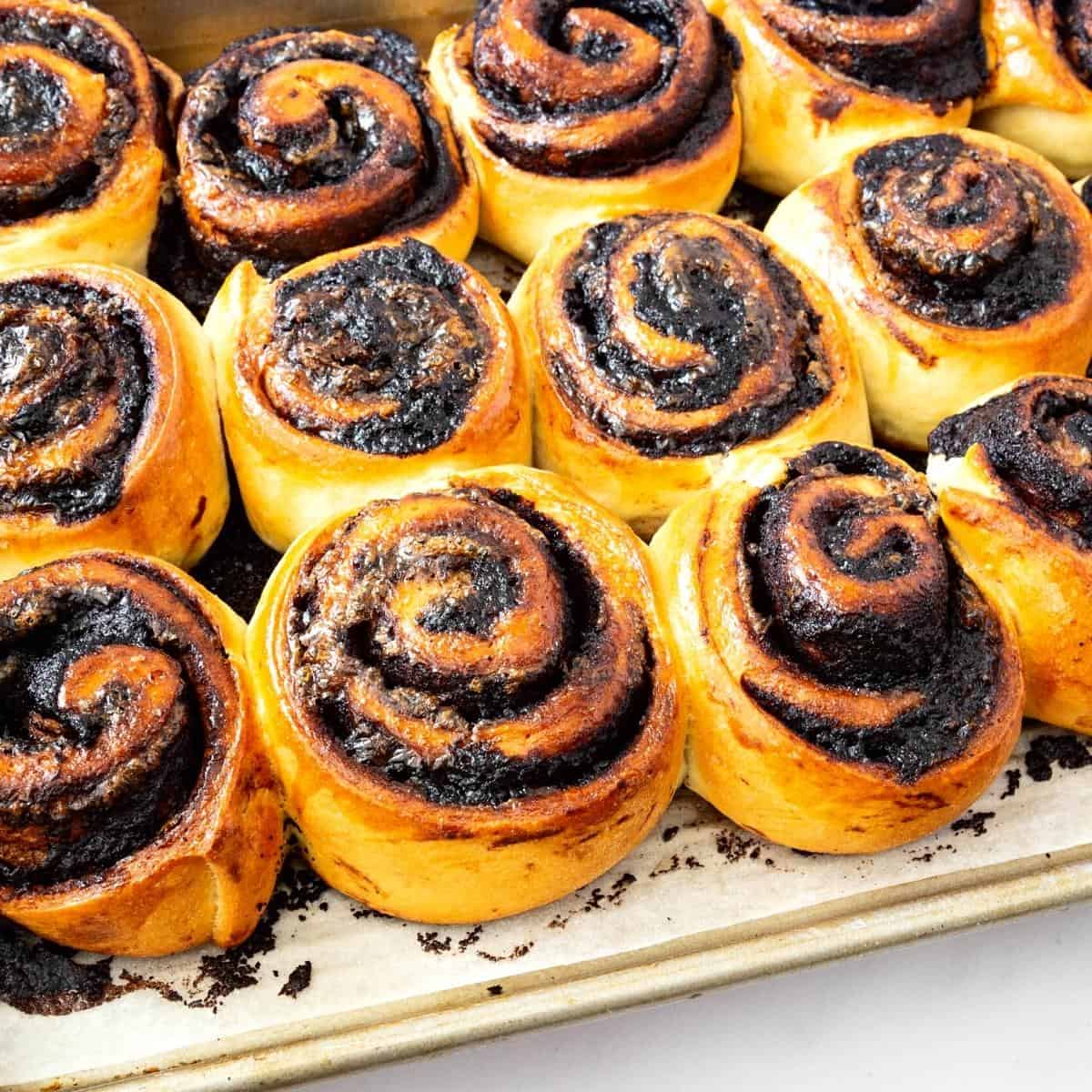 A baking tray with baked cinnamon rolls.