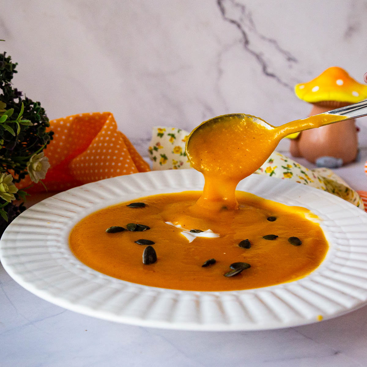 A bowl and soup with pumpkin soup.