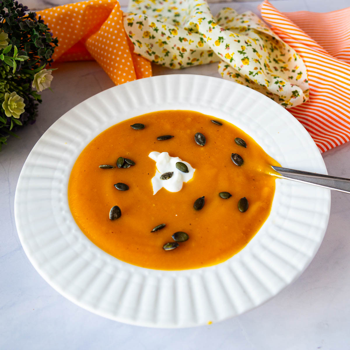 White bowl with orange soup.