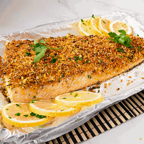 A baking tray lined with parmesan crusted salmon.