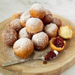 Donut holes on a wooden board.