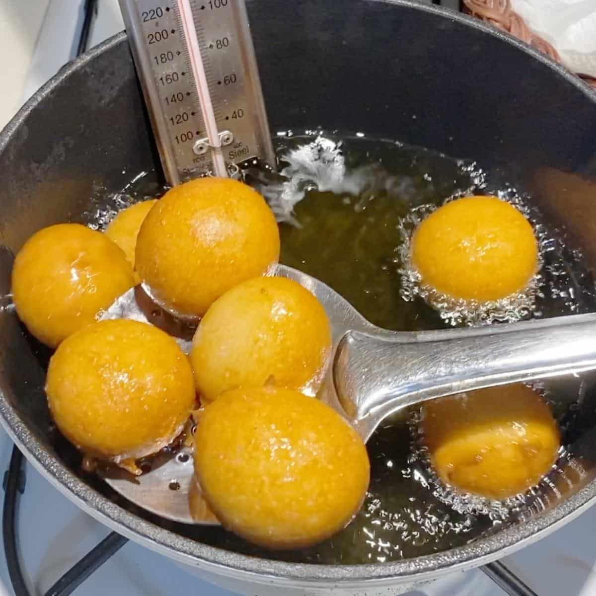 Deep frying donuts in a cast iron pot.