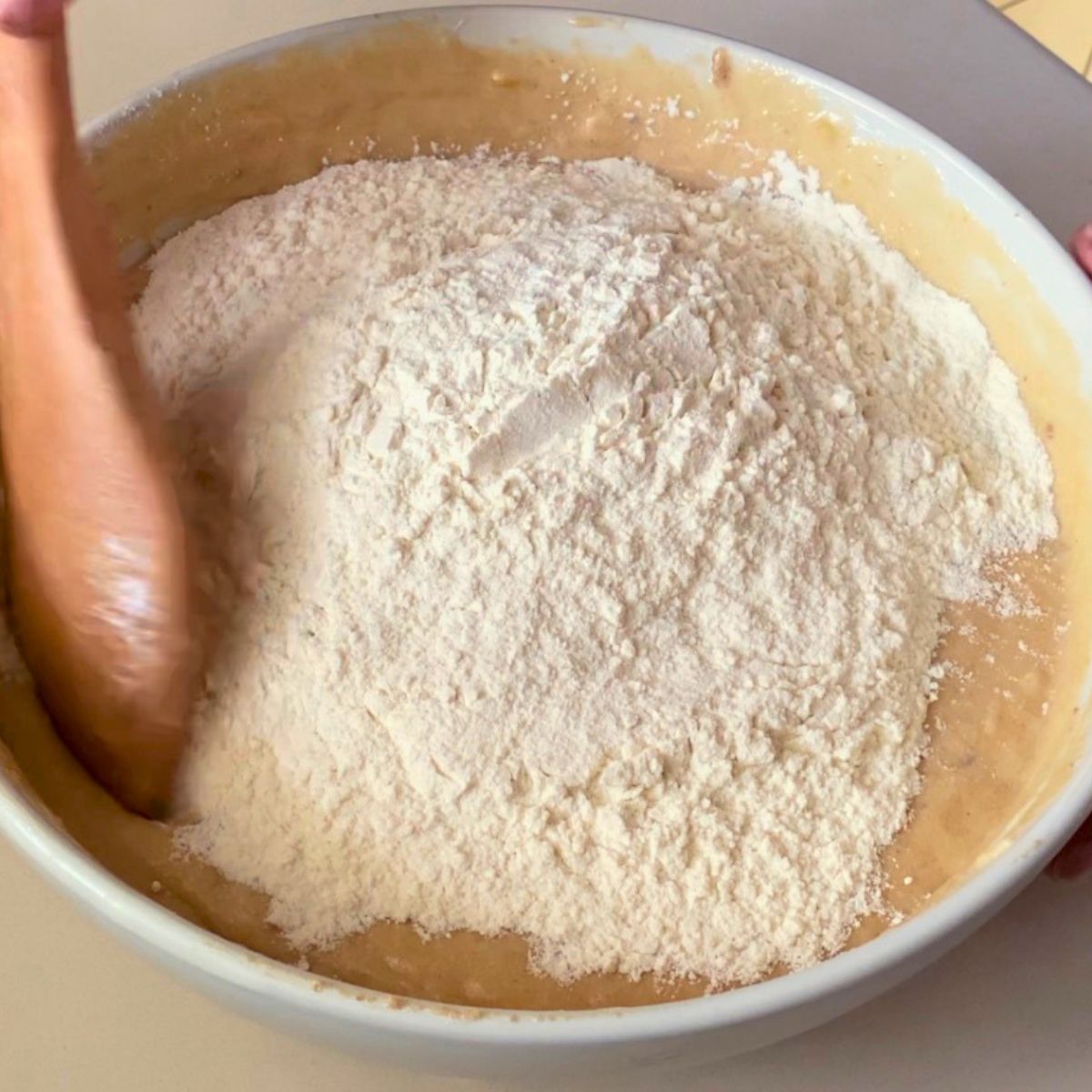 Adding flour mixture to the cake batter.