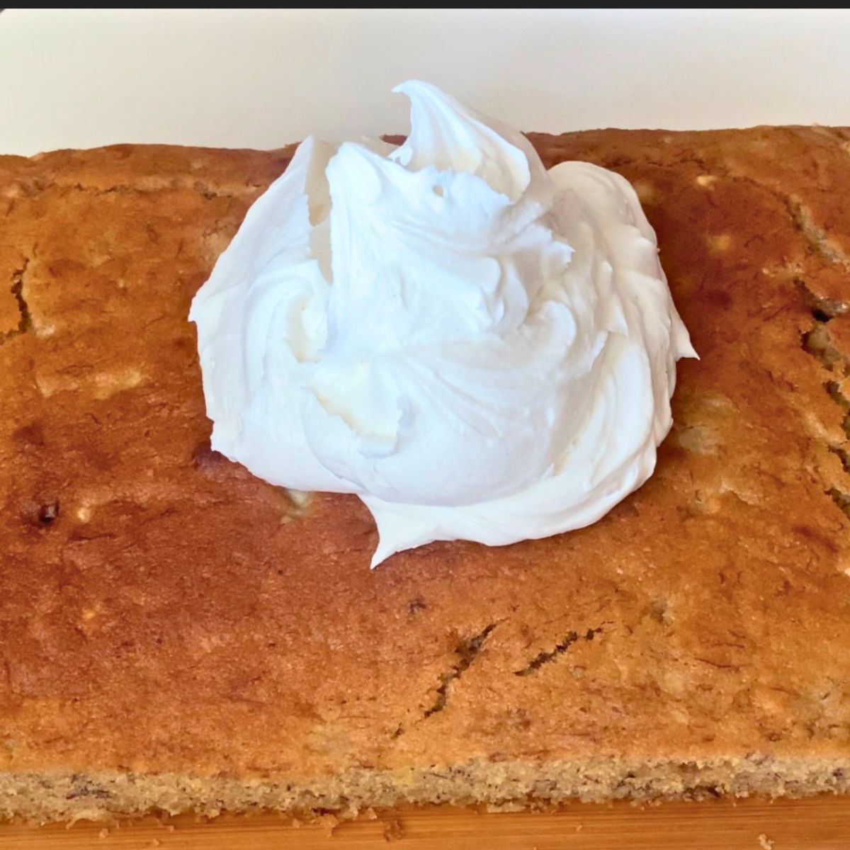 A frosted banana cake with cream cheese frosting.