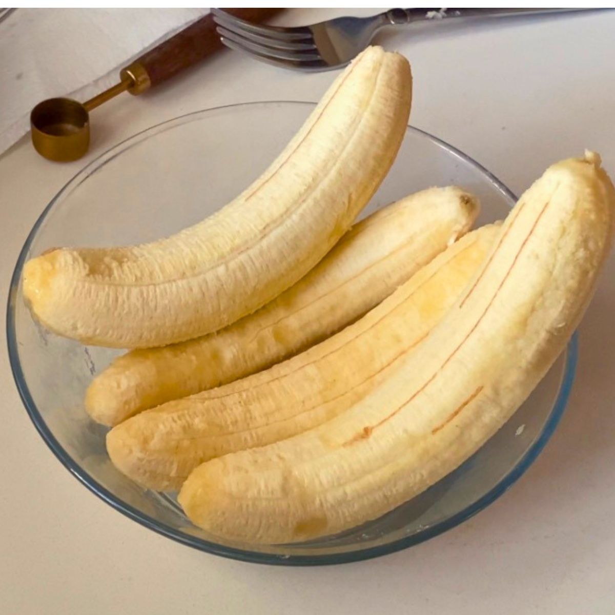 4 large peeled bananas in a bowl.