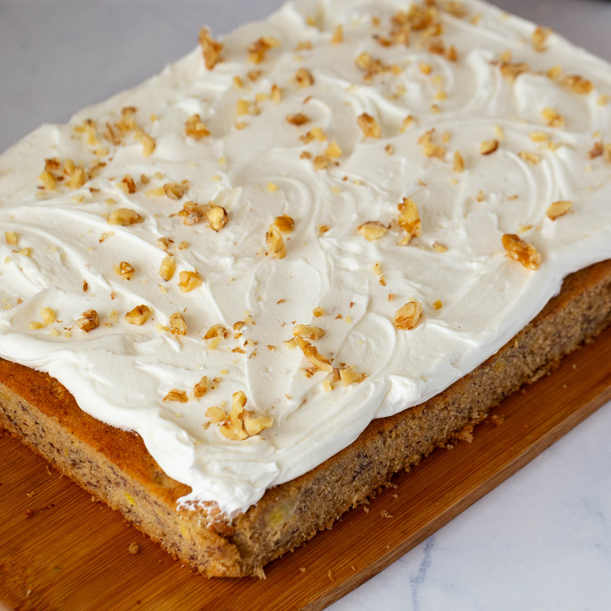 A frosted fresh banana cake on the table.