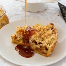 A slice of apple pie on the plate with caramel sauce.