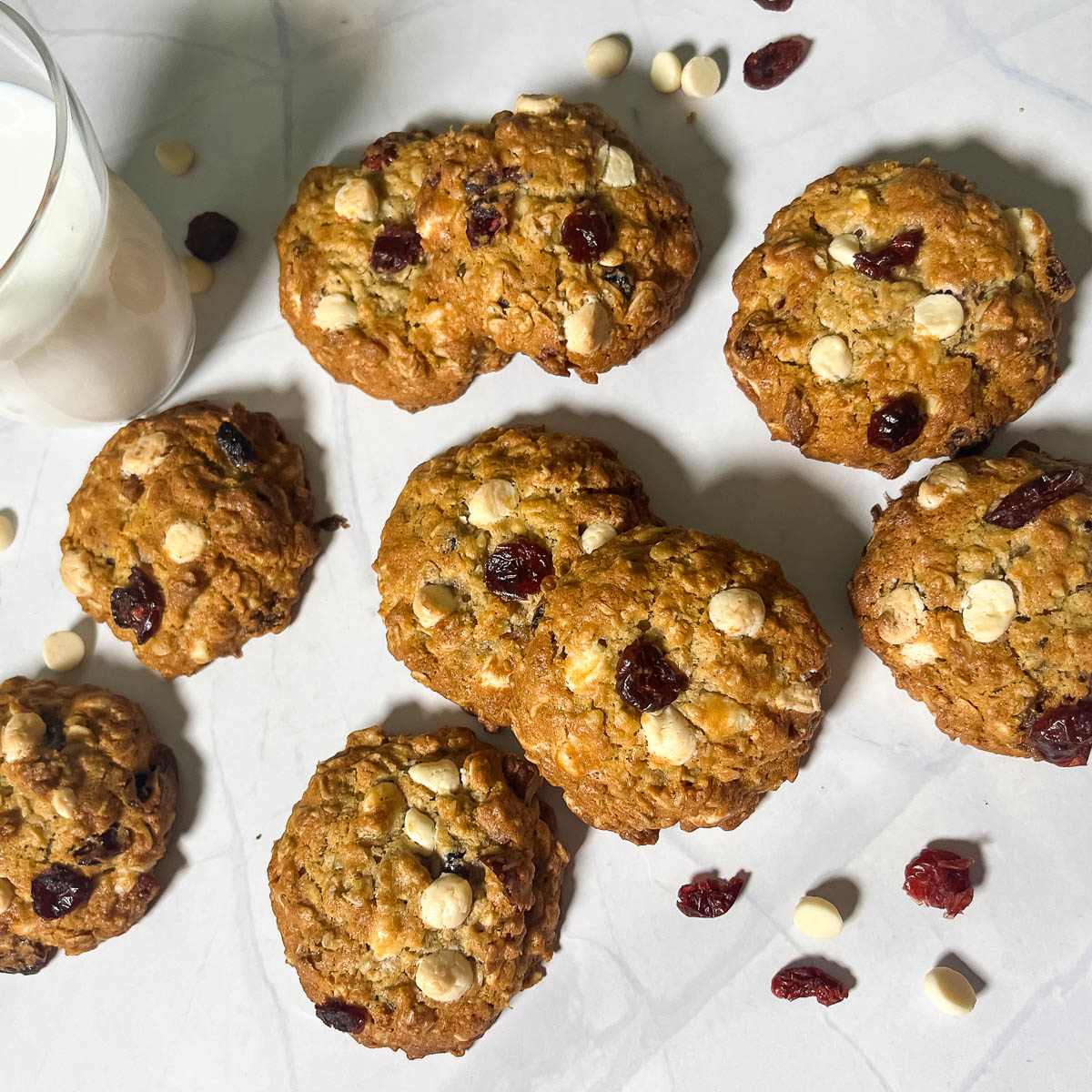 Oatmeal cookies on the parchment with cranberry and white chocolate chips.