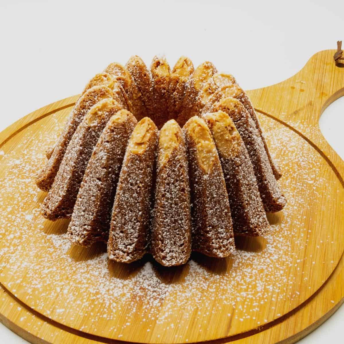 A marzipan bundt cake on a wooden board.