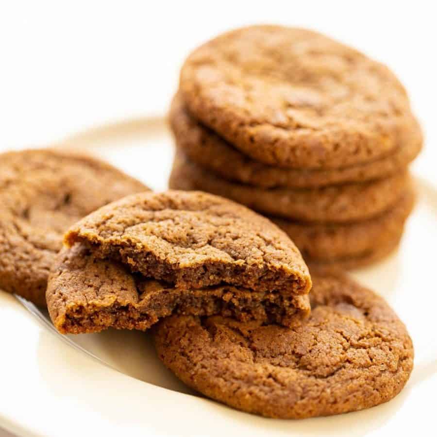 A stack of cookies on a white plate.