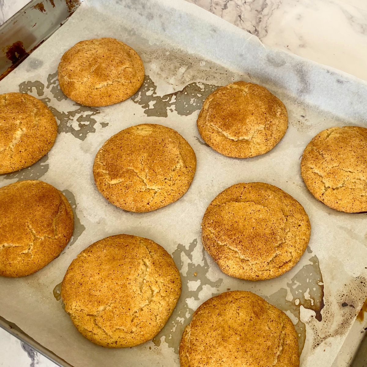 Fresh baked snickerdoodles on a baking tray.