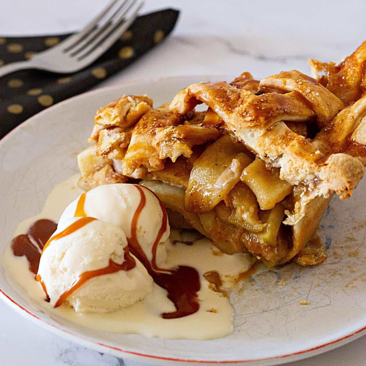 A slice of apple pie with caramel and ice cream.