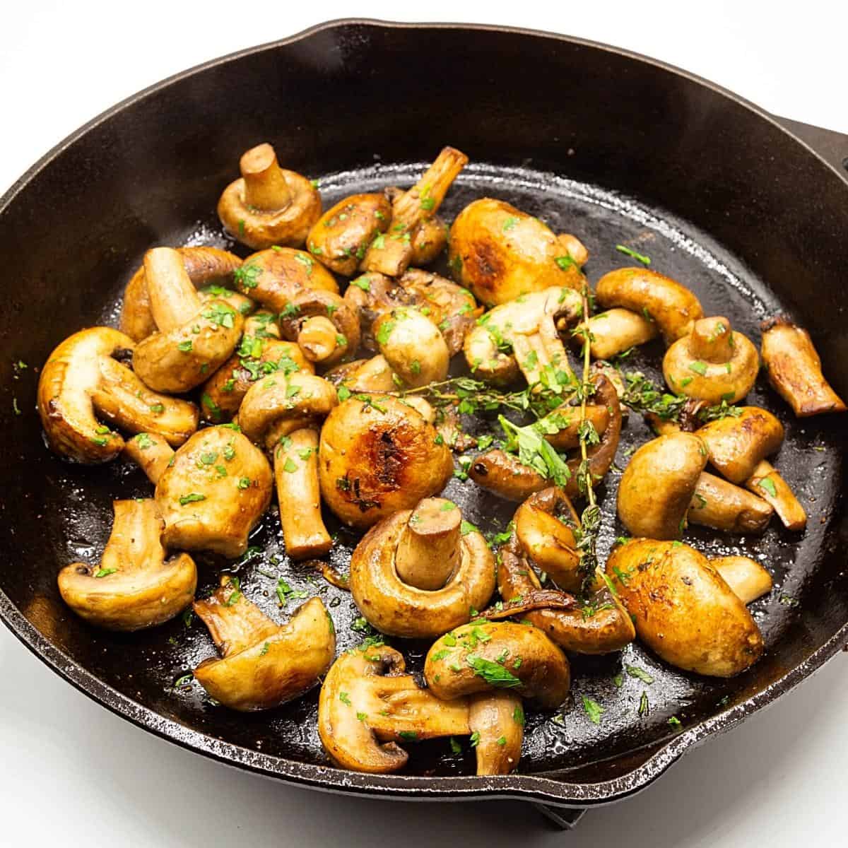 A skillet with mushrooms sauteed with garlic.