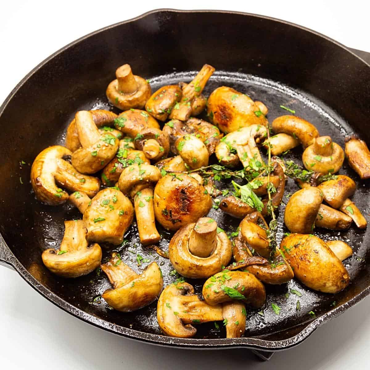 A skillet with sauteed mushrooms.