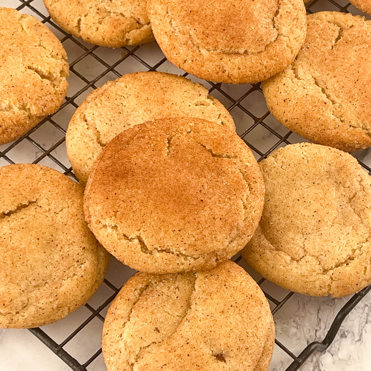 A Spread of snickerdoodle cookies on a wire rack.