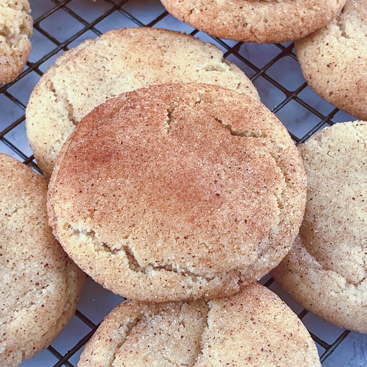 Snickerdoodle cookies on a wire rack.