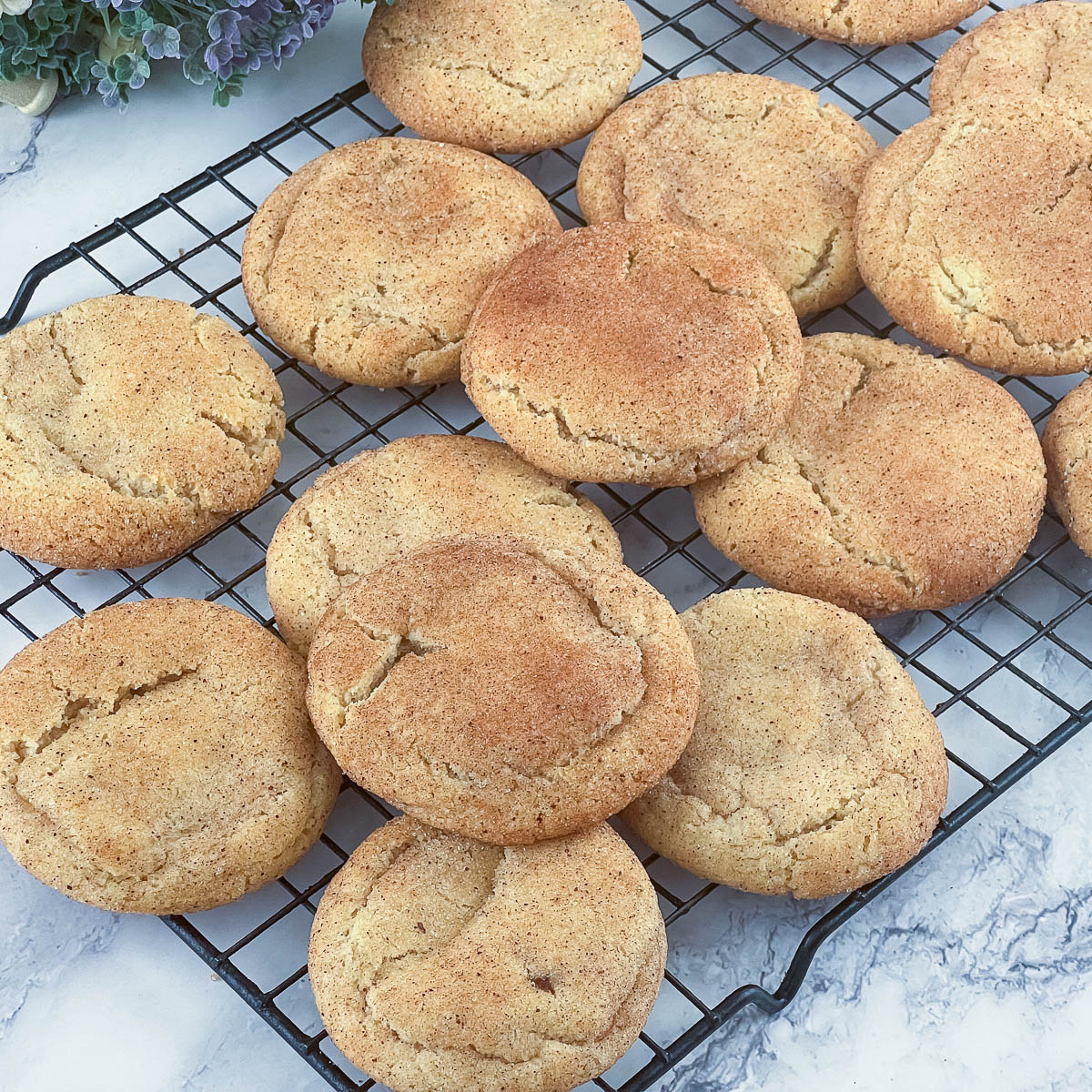 Fresh baked snickerdoodle cookies on a wire rack.