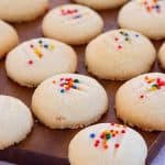 Whipped shortbread cookies on a wooden board.