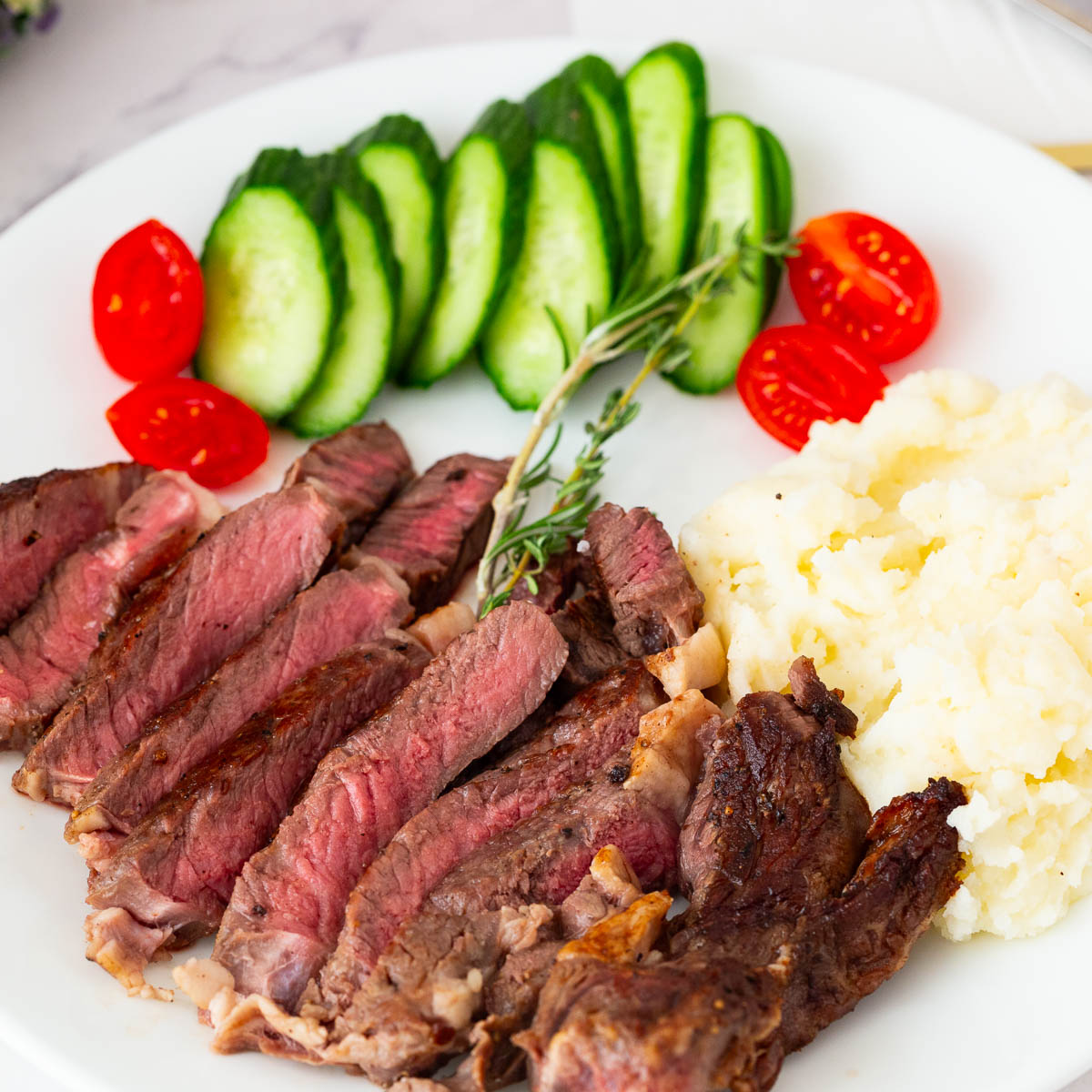 Med Rare Steak on the white plate with mashed potatoes.