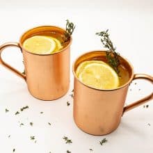 Two copper mugs with cocktail and lemon slices.