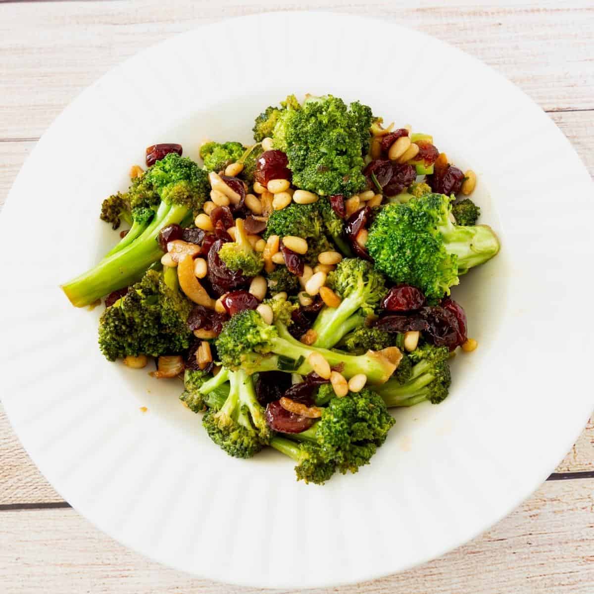 A bowl with sautéed broccoli with cranberries.