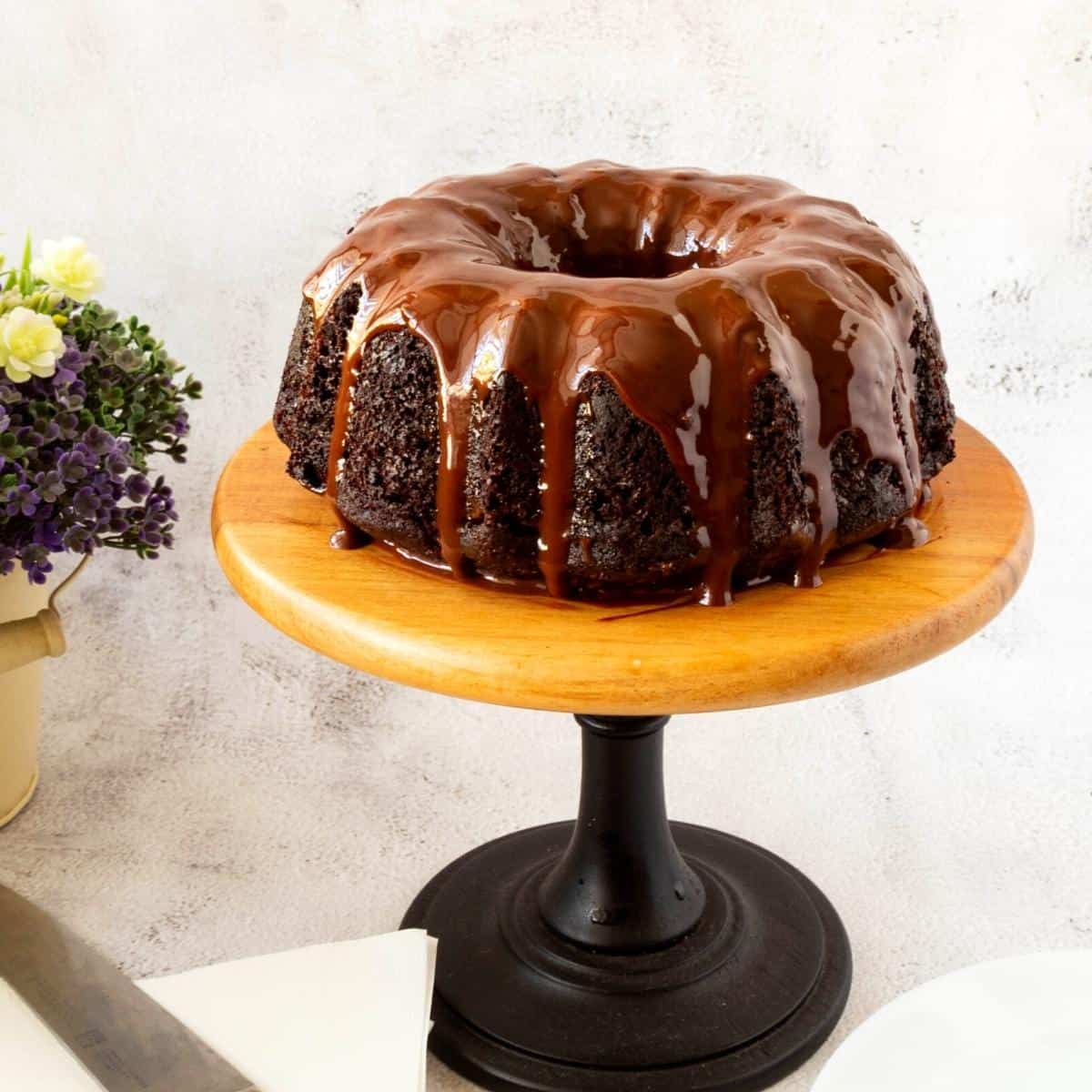 Bundt cake with chocolate glaze on the cake stand.