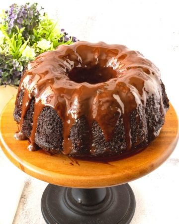 A chocolate cake with chocolate glaze on the cake stand