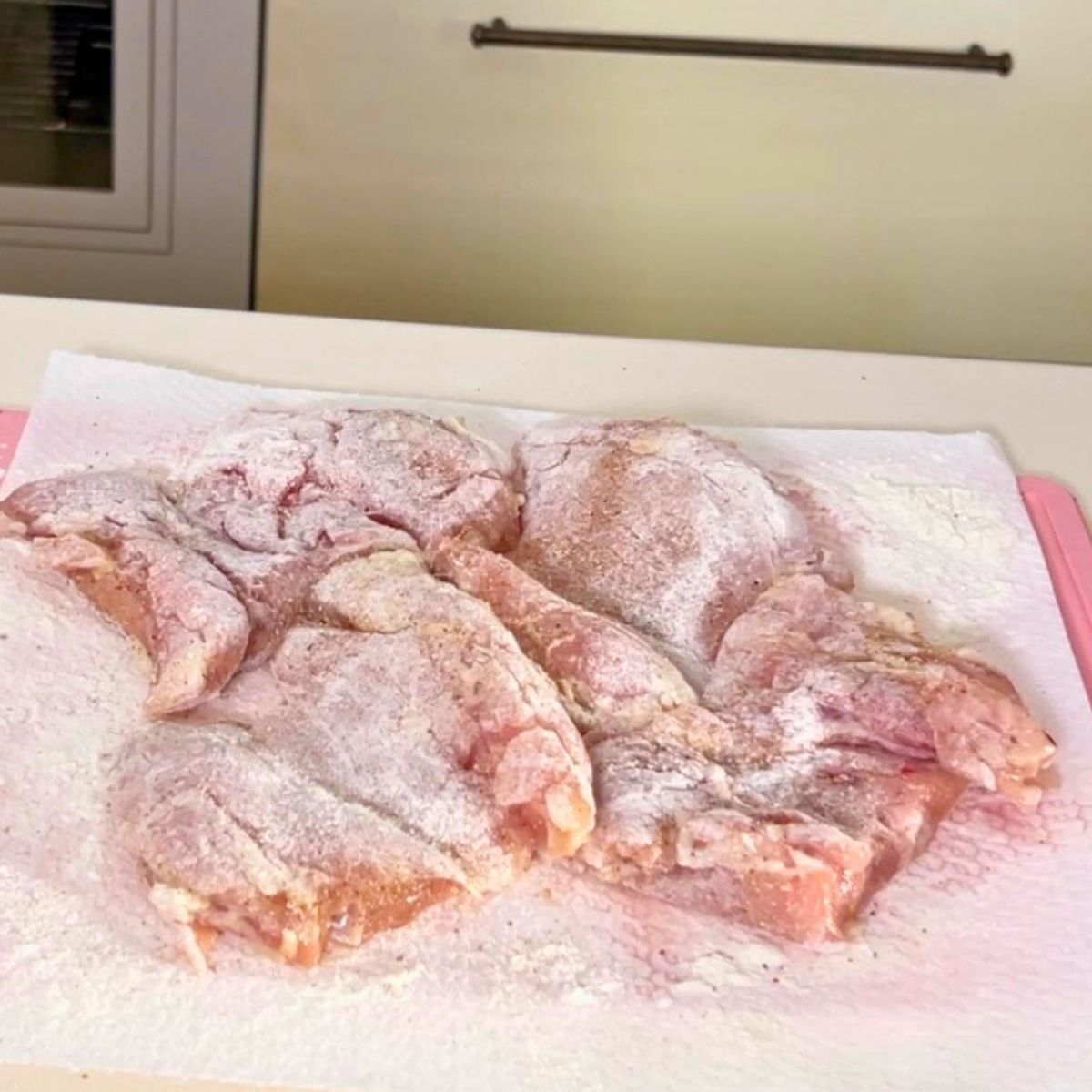 Progress pictures chicken breast seasoned and dusted with flour.