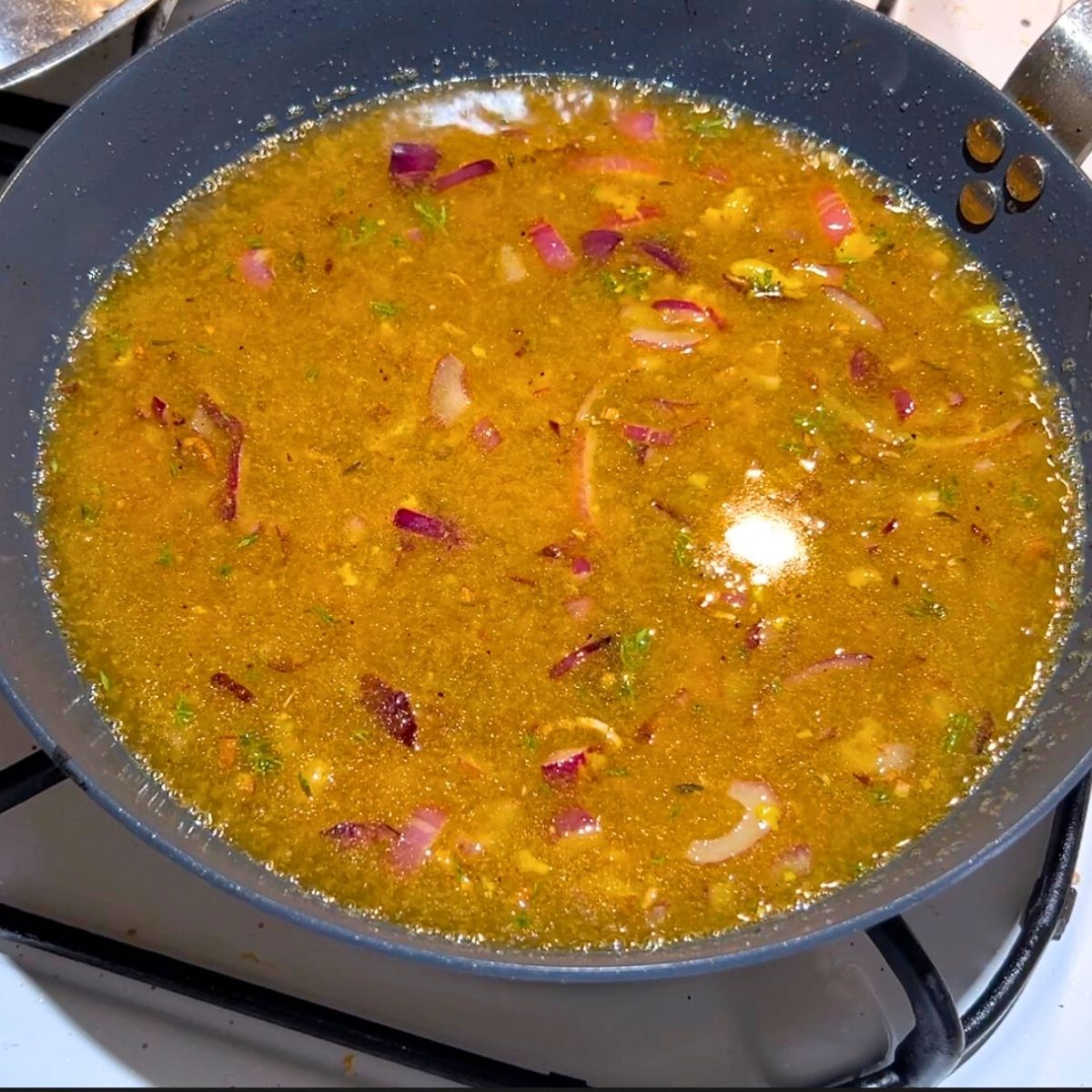 A skillet preparing the honey mustard sauce.