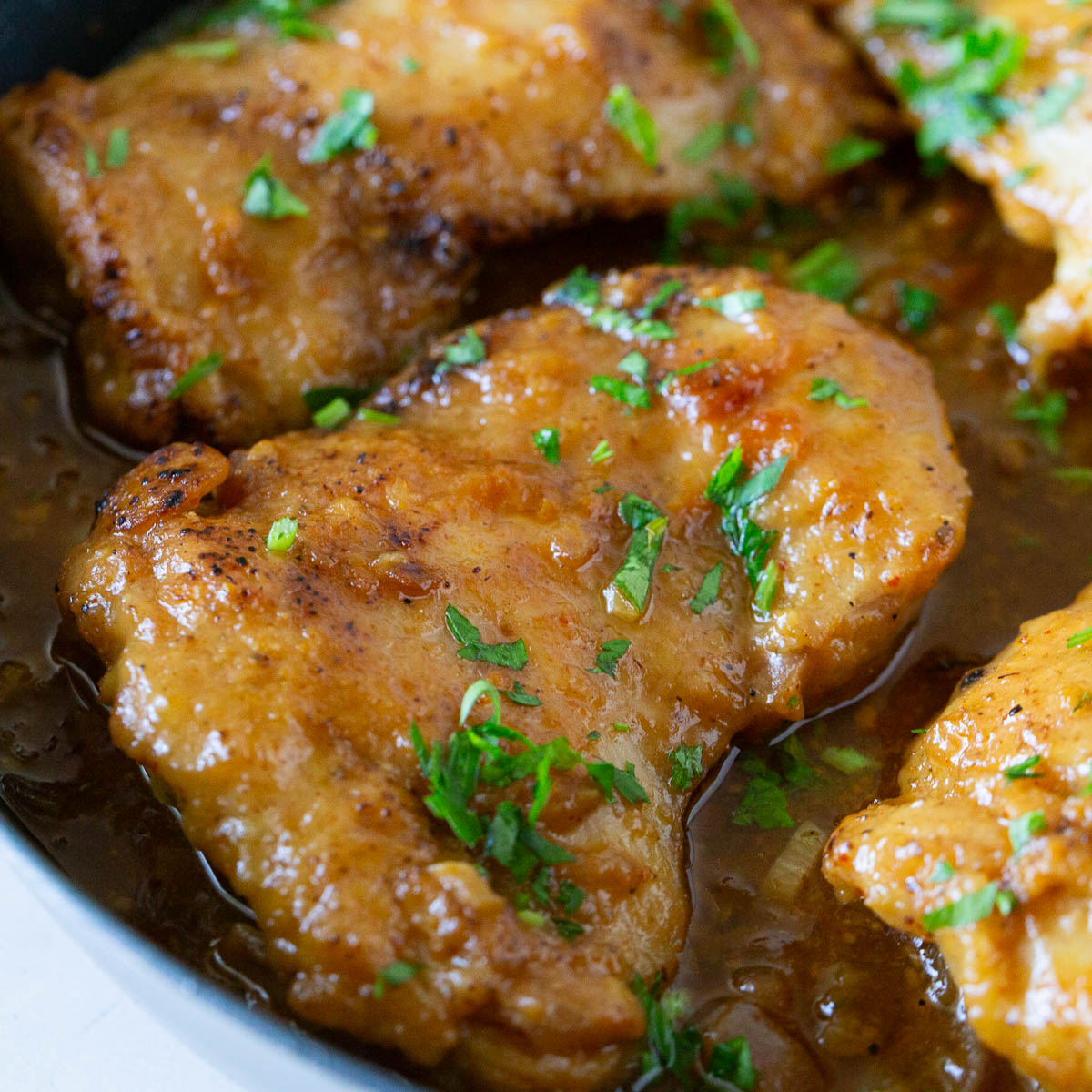 A skillet with saucy chicken.
