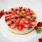 A mousse cake topped with jelly and fresh strawberries.