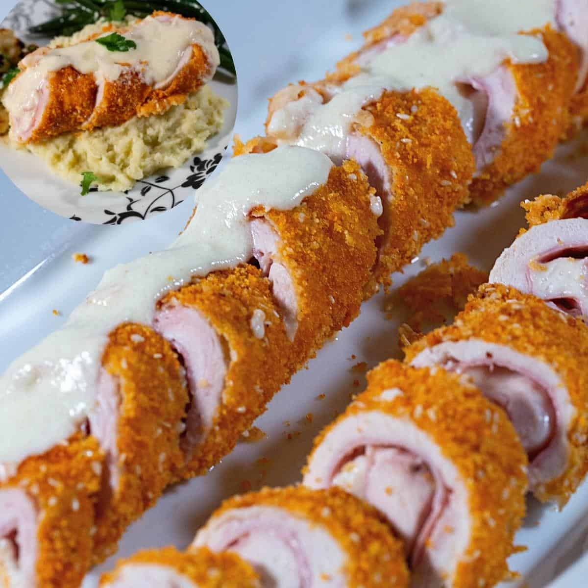 A chicken cordon bleu roulade topped with cheese sauce.