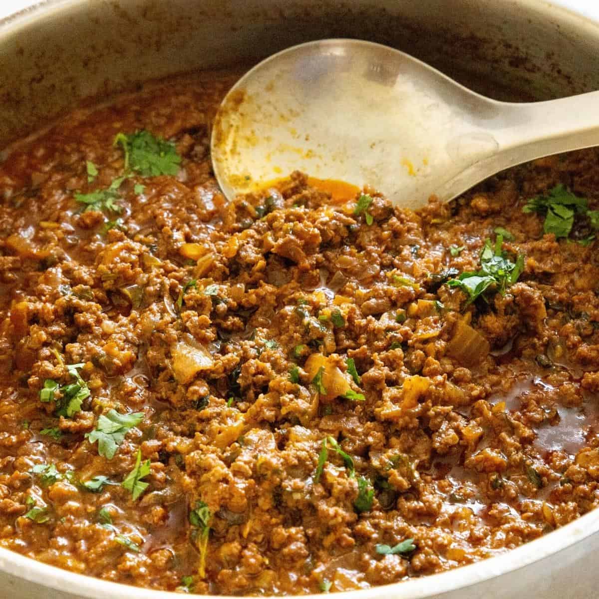 Indian curry with ground beef in a skillet.