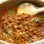 A large skillet with ground beef curry.