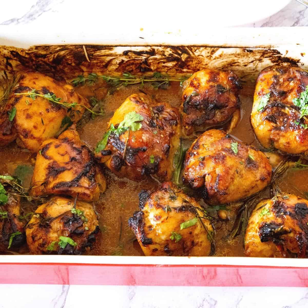 A baking dish with chicken thighs baked in juices.