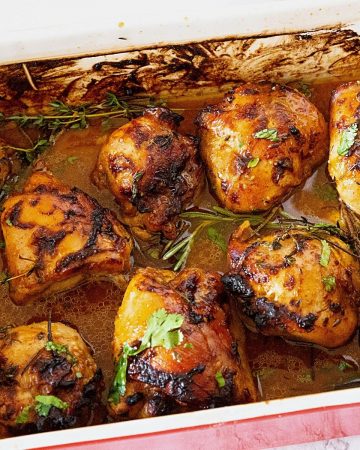 A baking dish with chicken thighs baked in juices.