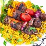 Three skewers on a bed of turmeric rice.