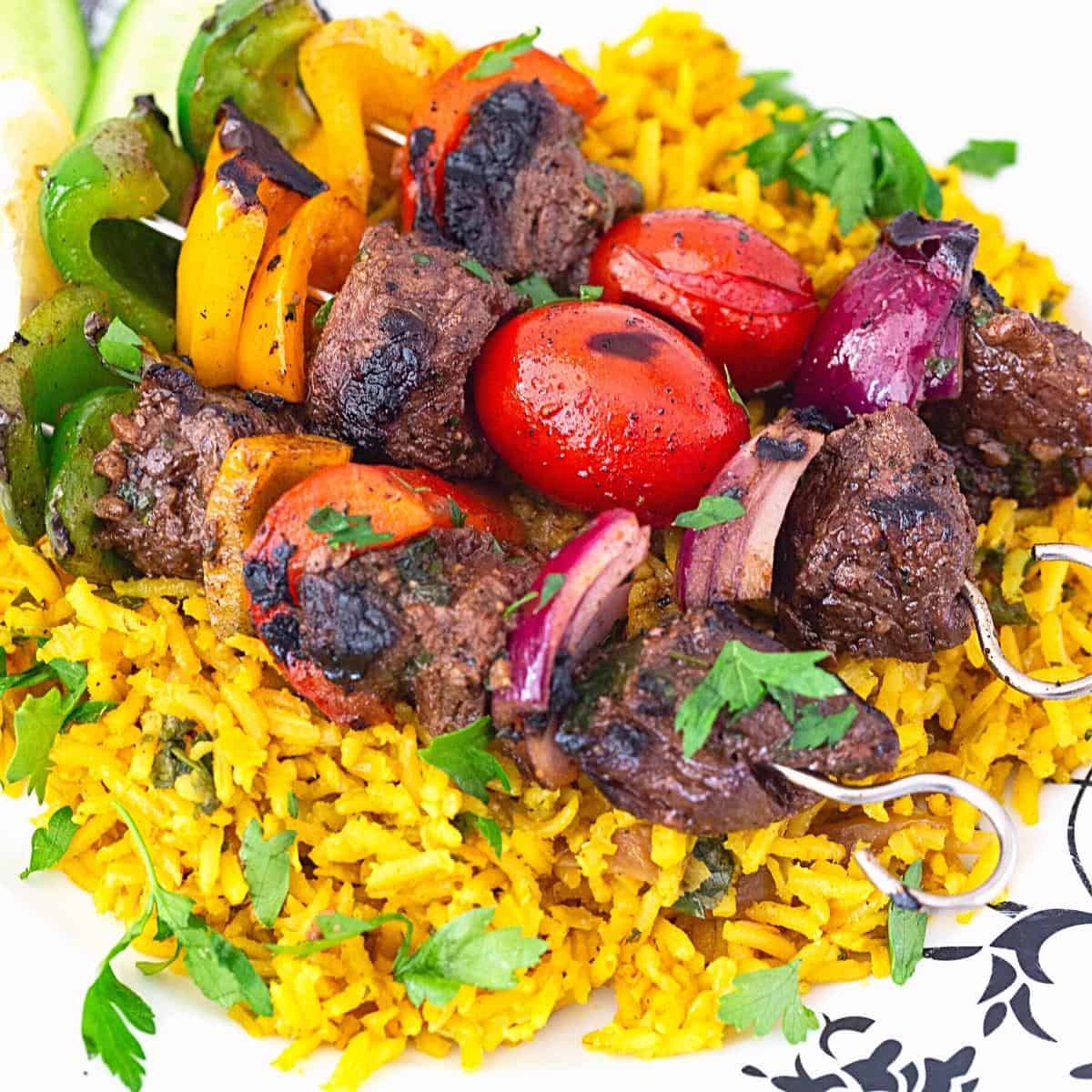 Three skewers on a bed of turmeric rice.