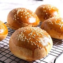 Baked buns on a cooling rack.