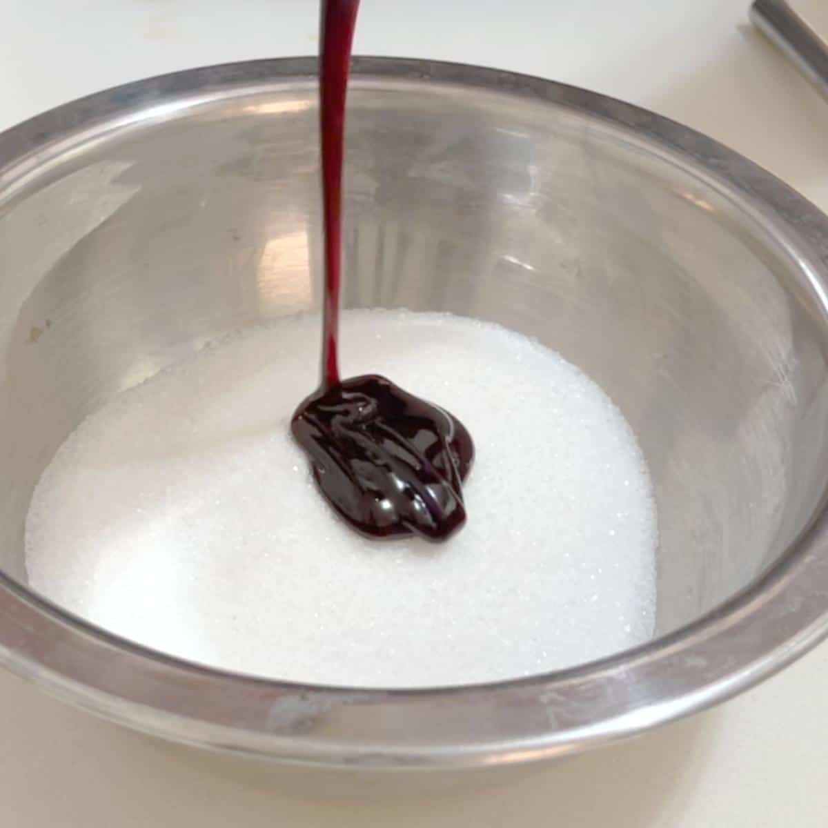 A bowl with white sugar and molasses.