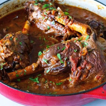 A dutch oven pan with braised lamb shanks.