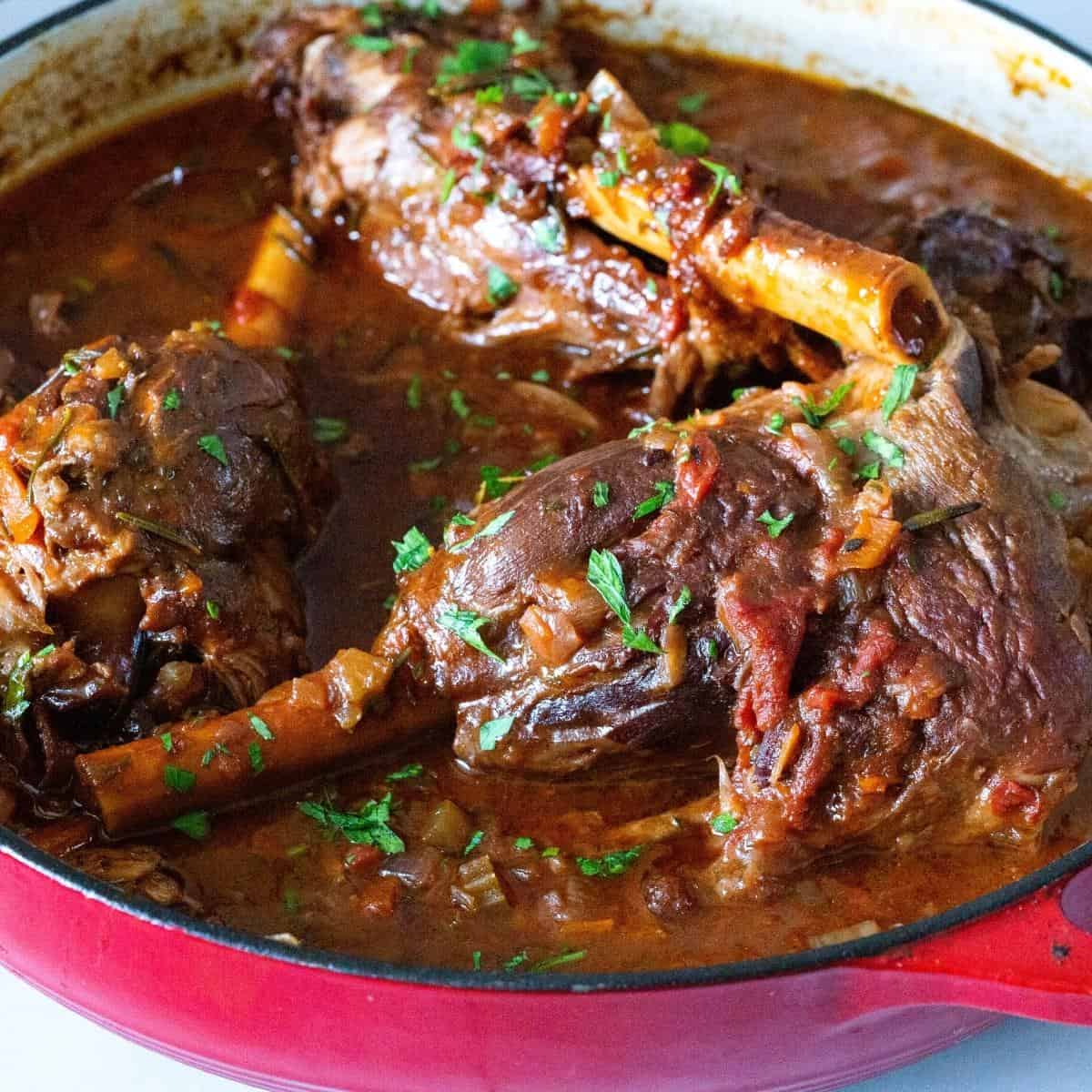 A dutch oven pan with braised lamb shanks.