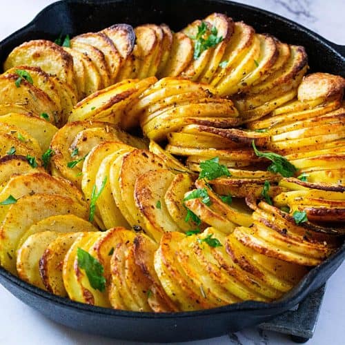 A skillet with sliced baked potatoes.