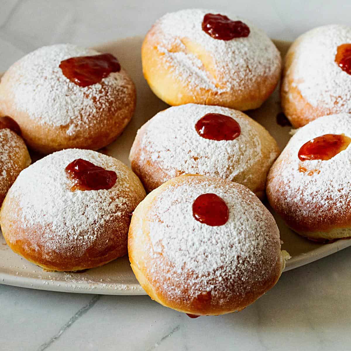 Jam donuts on a platter.