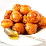 Loukoumades donuts on a plate with honey.