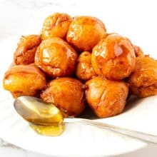 Loukoumades donuts on a plate with honey.