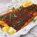 A large salmon fillet on the baking tray.