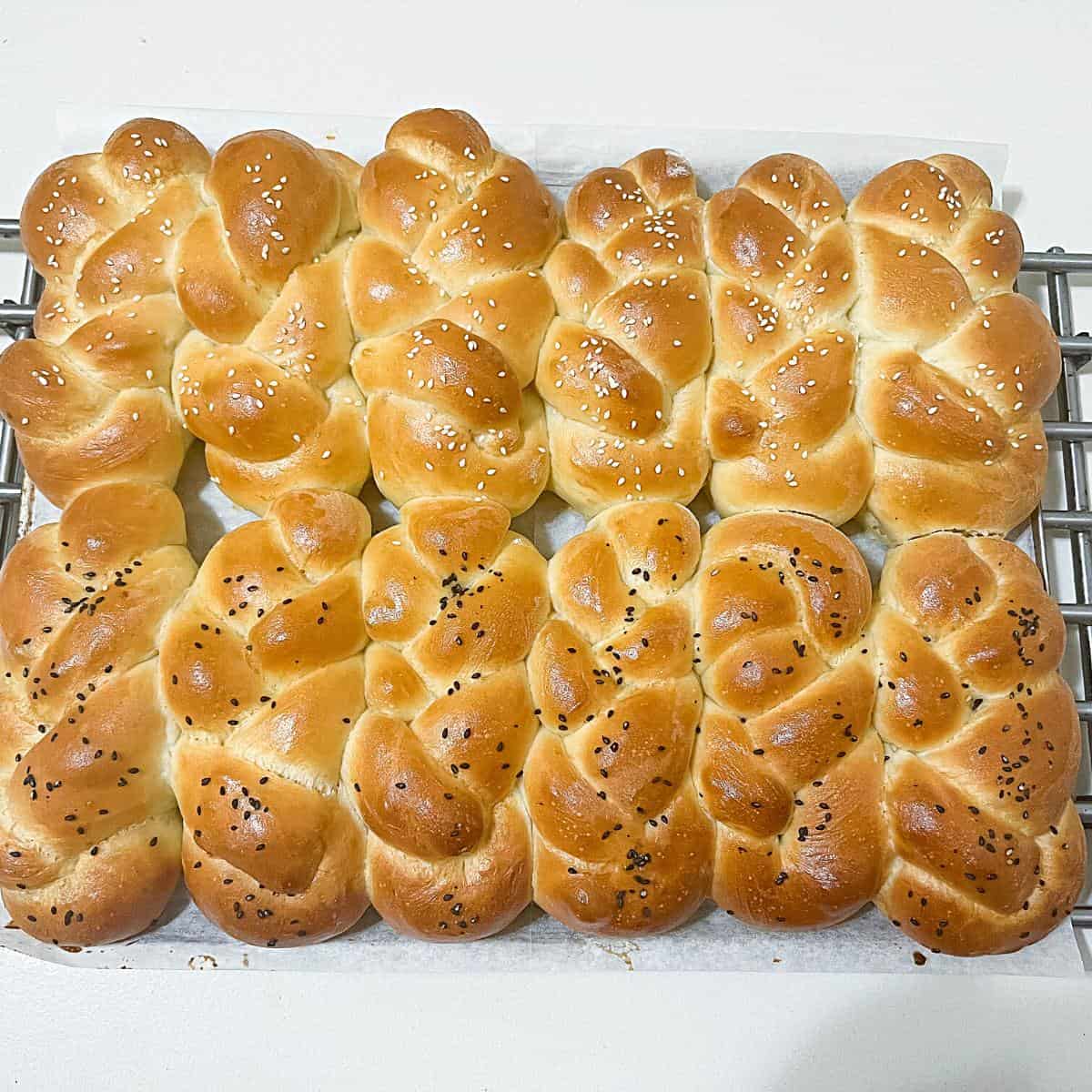 Braided challah rolls on the cooling rack.