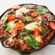 A cast iron skillet with focaccia and pesto.